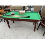 A SNOOKER TABLE WITH BALLS, TRIANGLE AND CUES