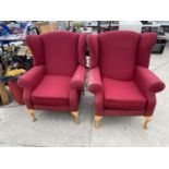 TWO RED WING BACK ARMCHAIRS ON BEECH CABRIOLE SUPPORTS