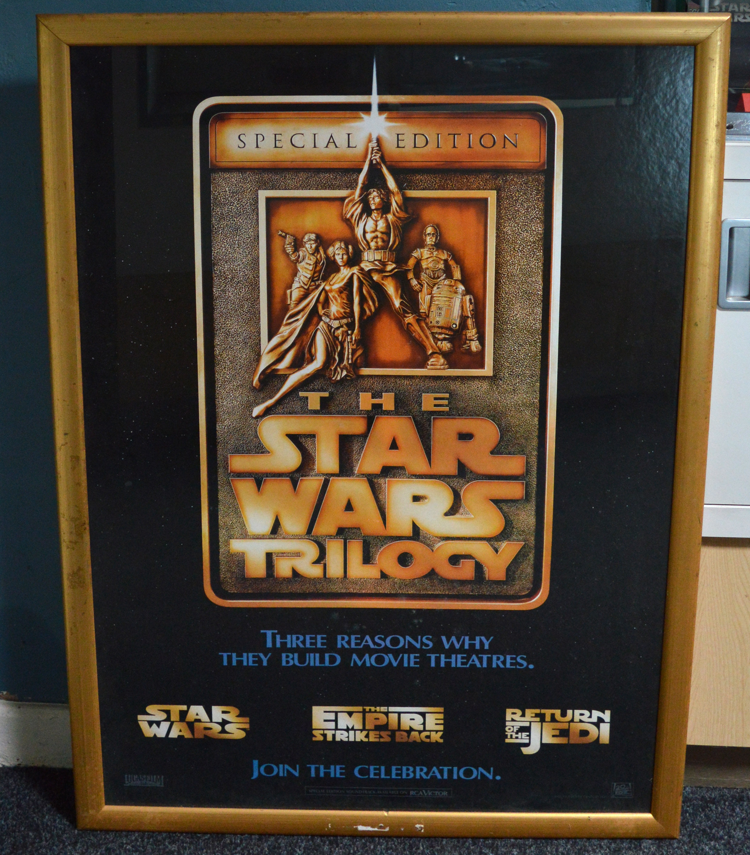 Two large glazed frames containing Star Wars inspired wall art and a Star Wars Trilogy poster.