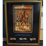 Two large glazed frames containing Star Wars inspired wall art and a Star Wars Trilogy poster.