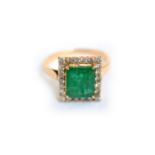 An emerald & diamond cluster ring, tested to approx 14ct, emerald measures approx 8.7mm x 7.6mm (