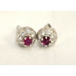 A pair of ruby & diamond ear-studs, the round rubies measure approx 4.2mm each, the diamonds total