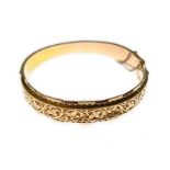 A 9ct 1930's decorated hinged bangle, H/M Birmingham 1938, A/F - some dents & wear, approx 12.8gms