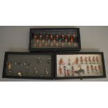 54 unboxed Britains metal soldier figures contained in three glass lidded display trays.