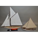 A plastic model of a sailing boat with single mast and  two sails, length approximately 55cm,