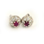A pair of ruby & diamond ear-studs, the round rubies measure approx 4.2mm each, the diamonds total