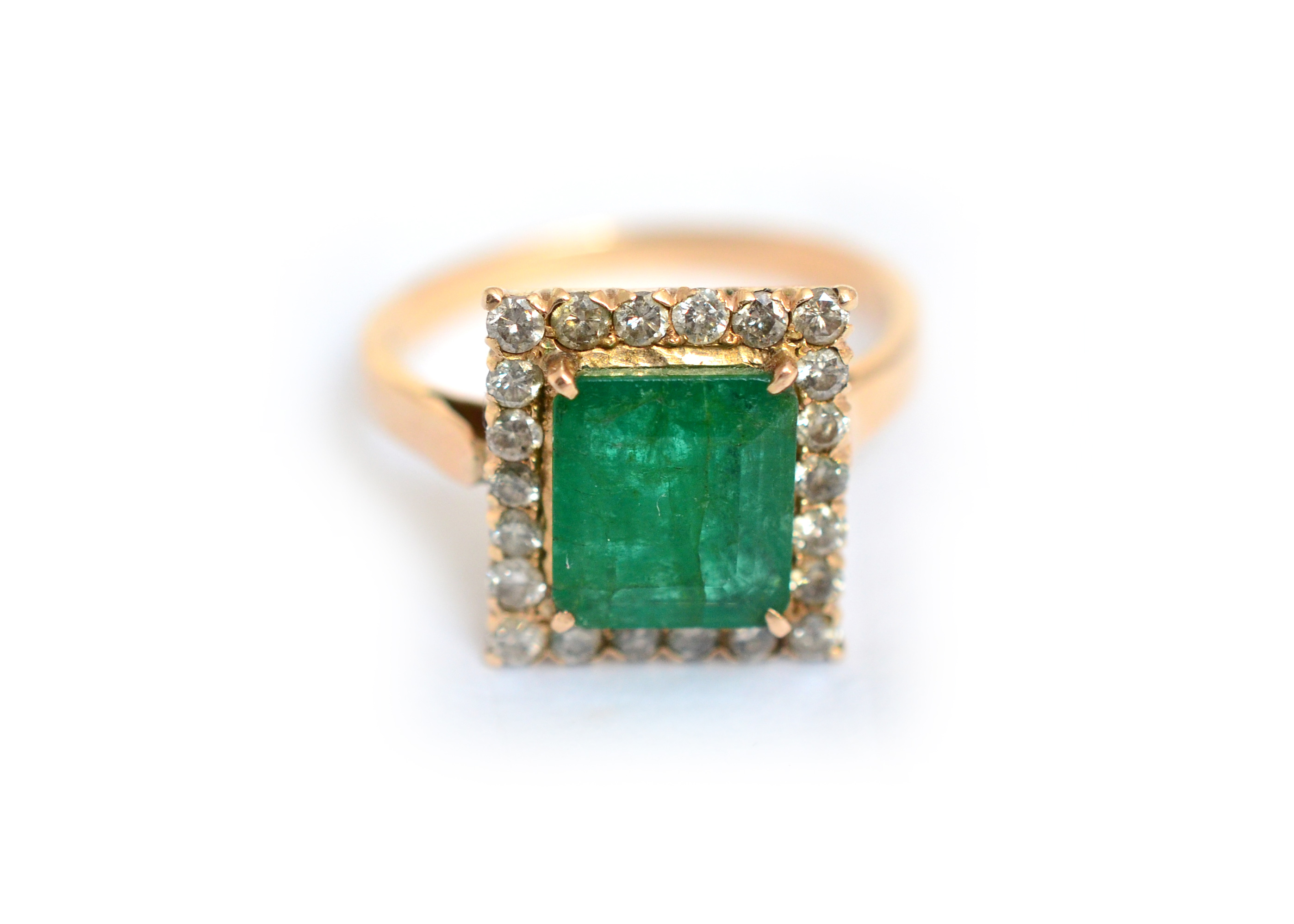 An emerald & diamond cluster ring, tested to approx 14ct, emerald measures approx 8.7mm x 7.6mm (