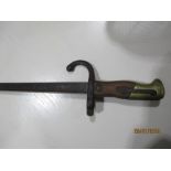 A French Gras bayonet with wooden handle and brass mounts inscribed "Mre de Armes de St. Etienne