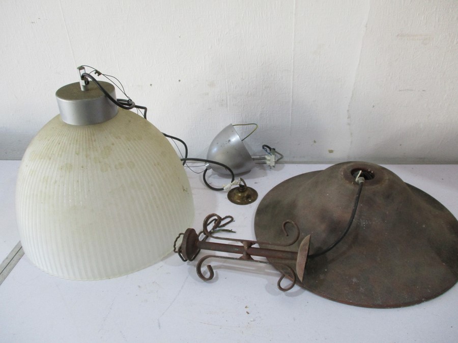 A cast iron lamp shade along with a modern holophane style shade