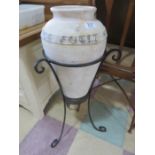 A decorative urn on wrought iron stand