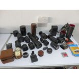 A collection of various camera lenses, flash meters etc