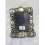 A hallmarked silver photo frame decorated with cherubs, Chester