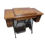 A vintage oak Singer treadle sewing machine with cast iron base