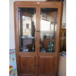 A large corner cupboard with glazed top and cupboard under