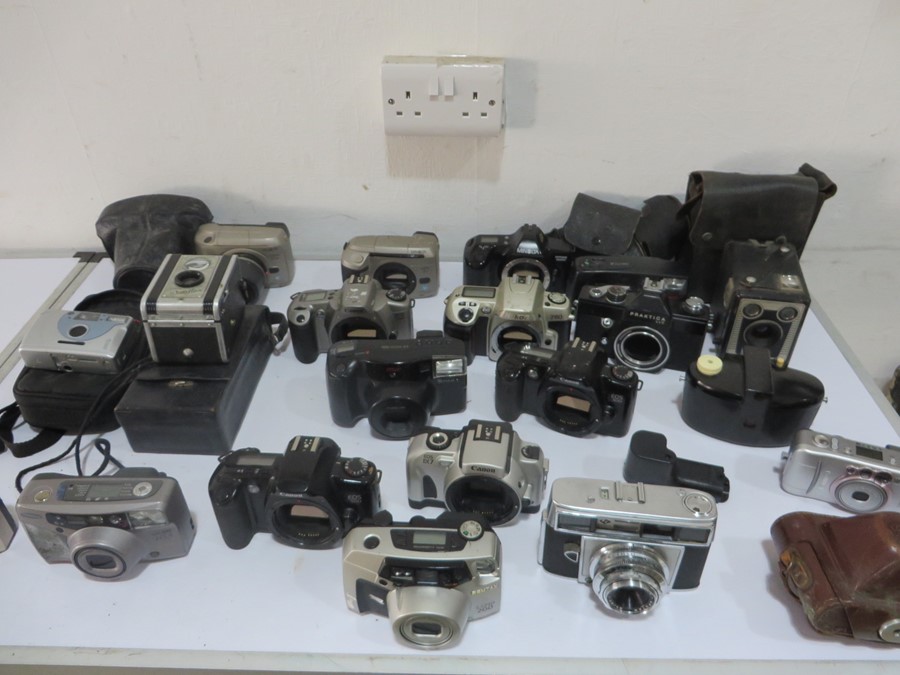 A collection of various cameras including Kodak, Canon, Brownie, Praktica, Pentax etc