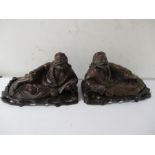 A pair of Oriental hard wood carved recumbent figures on stands, overall length 35cm