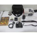 A Canon 550D digital camera with 18-55mm zoom lens in box along with accessories