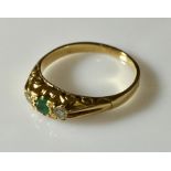 An 18ct gold ring with emerald and diamonds.