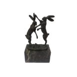 A bronze figure of hares fighting, signed "Nick" on marble base - 25cm H