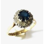 A 18ct gold ring with central sapphire and a diamond surround.