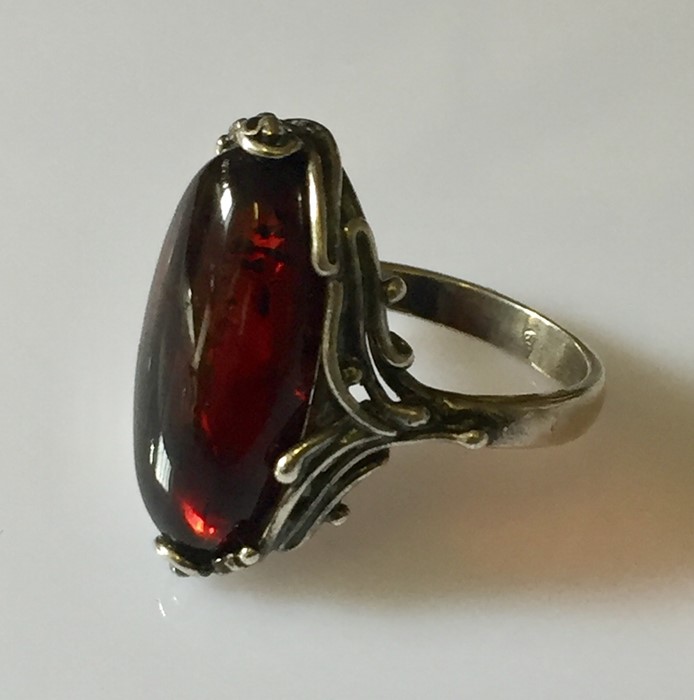 A silver ring with dark amber stone