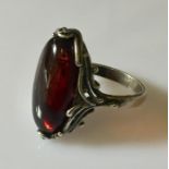 A silver ring with dark amber stone