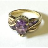 A 10ct gold ring with 'tear drop' amethyst and diamond surrounds.