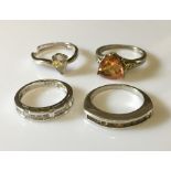 Four silver dress rings.