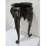 A 19th century jardiniere stand, the round top supported by three elephant heads with glass eyes- 75