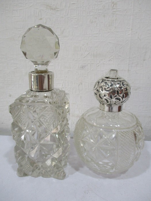 A silver topped scent bottle (London 1915) along with one other with silver collar (London 1919)