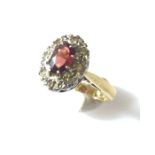 18ct gold ring with central garnet and diamond surround.