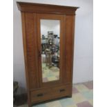 An oak Arts and Crafts mirror door wardrobe with drawer under