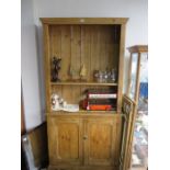 An antique pine dresser with glazed doors and cupboard under