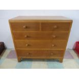 A mid century oak chest of five drawers