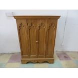 A pine gothic style television cabinet along with a small wine rack