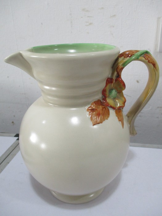 A Clarice Cliff jug with relief moulded floral handle 22.5cm height