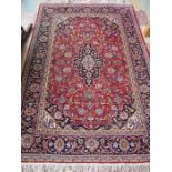 A red ground rug of traditional design, 203cm x 133cm