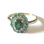 A 9ct gold emerald, diamond and dioxide cluster ring
