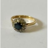 An 18ct gold ring with sapphire and diamond surround.