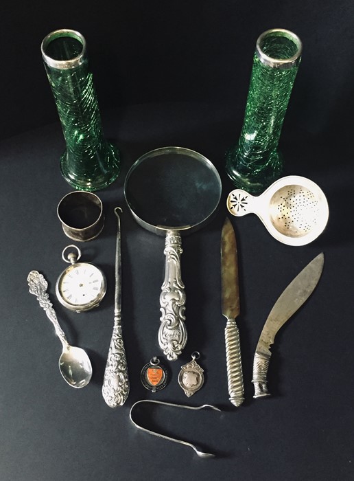 A collection of silver and SCM items including a magnifying glass, strainer, medallions etc.