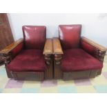 A pair of leather club chairs with oak arms