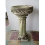 A concrete bird bath on Corinthian column