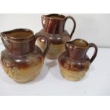 Three graduated harvest jugs, one marked Doulton Lambeth and two unmarked