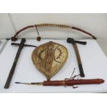 A collection of ethnological items including bow, shield, arrows and quiver and axes