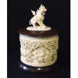 An antique Oriental carved ivory pot and cover, the top surmounted with a dragon- the tail of dragon