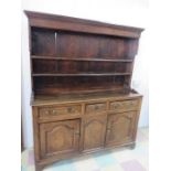 An early paired oak and elm dresser with three cupboards under