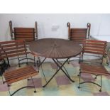 A folding teak and iron round garden table and four chairs