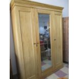 An antique pine triple wardrobe