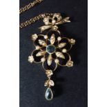 An Art Nouveau pendant and integral chain in 15ct gold set with seed pearls.