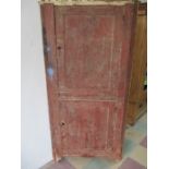 An antique pine corner cupboard